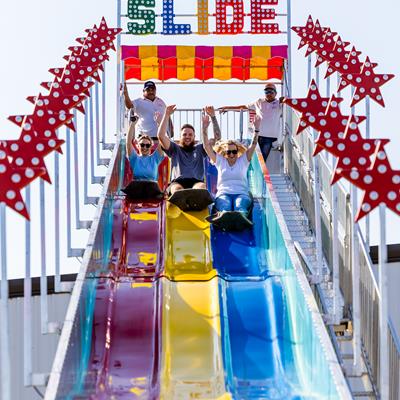 Group of co-workers going down a fun slide at the Loan Officer retreat