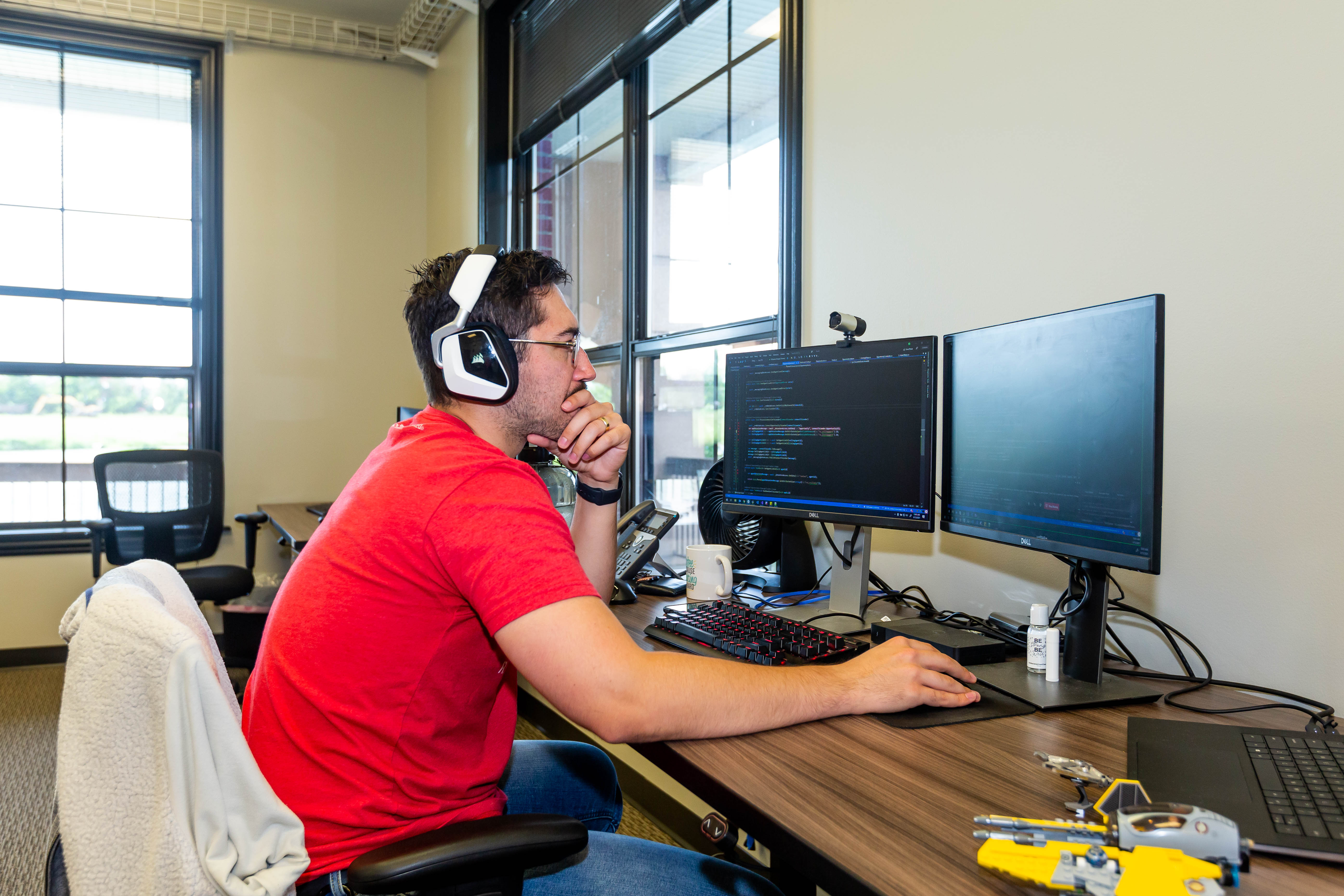 A man looking at two computer monitors