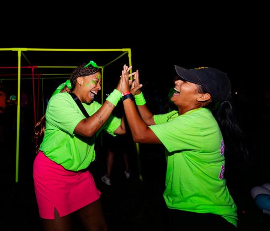 Two VUers high-fiving at Neon Gauntlet