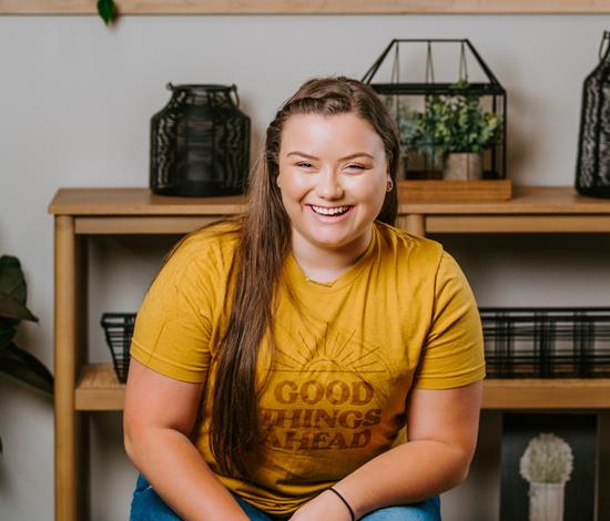 A woman smiling in front of plants