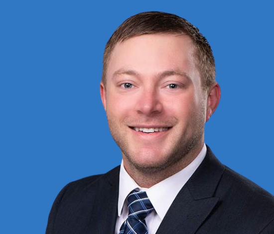 A man with short hair in a suit and tie