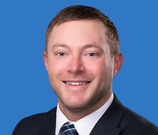 A man with short hair in a suit and tie